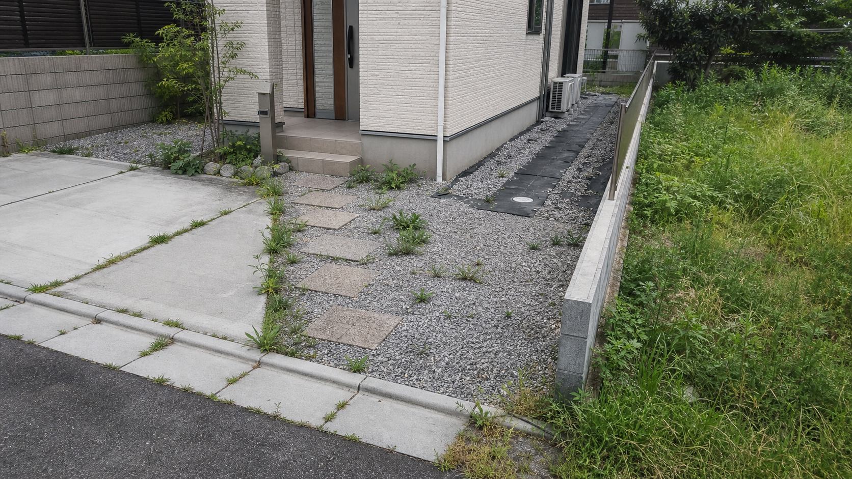 玄関アプローチや駐車場や庭まわりの雑草が残る一戸建て外構