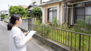 空き家の草刈り補助金を確認しながら伸びた庭を見ている様子