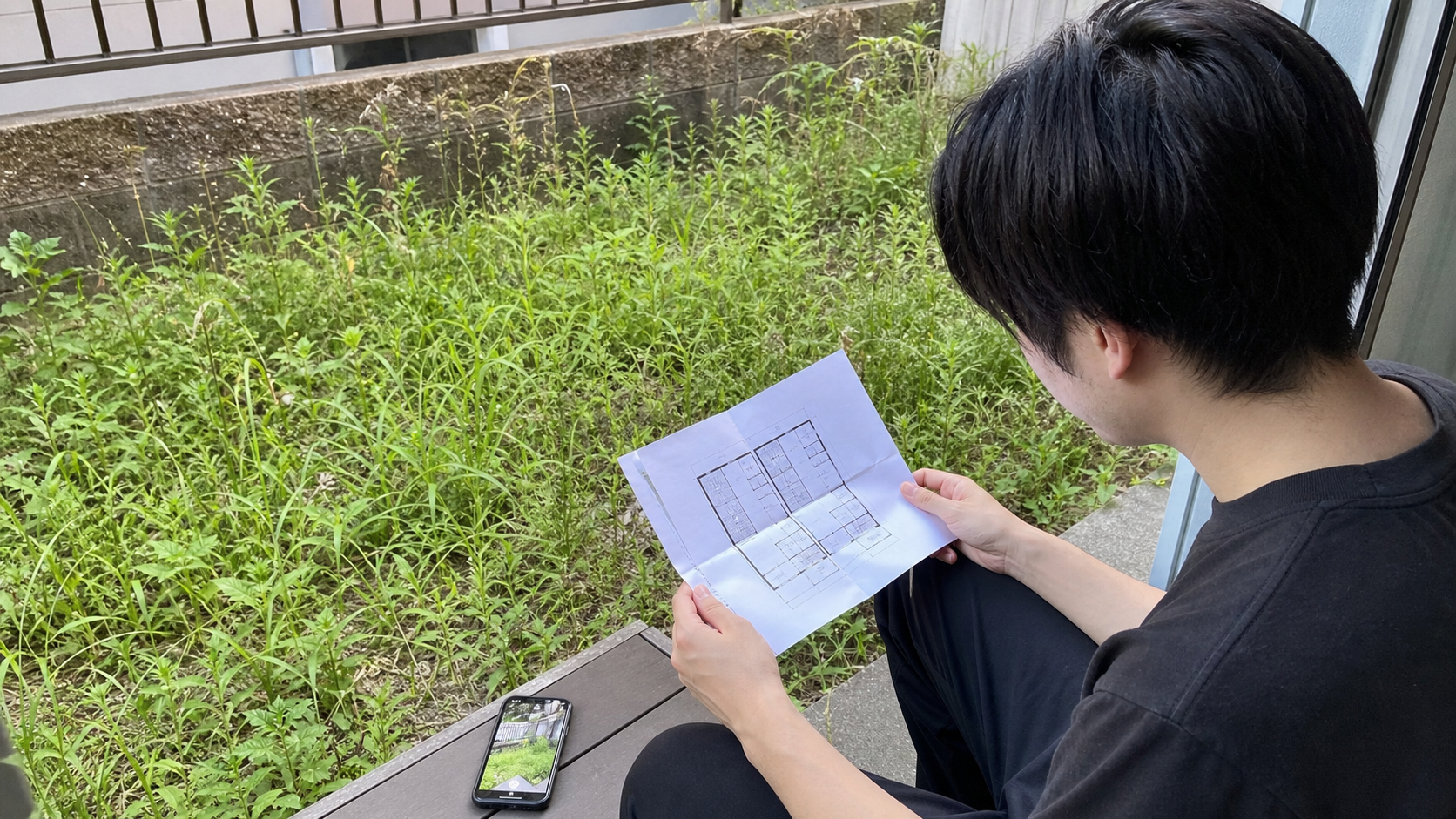 賃貸の庭の雑草管理を契約書と写真で確認する様子