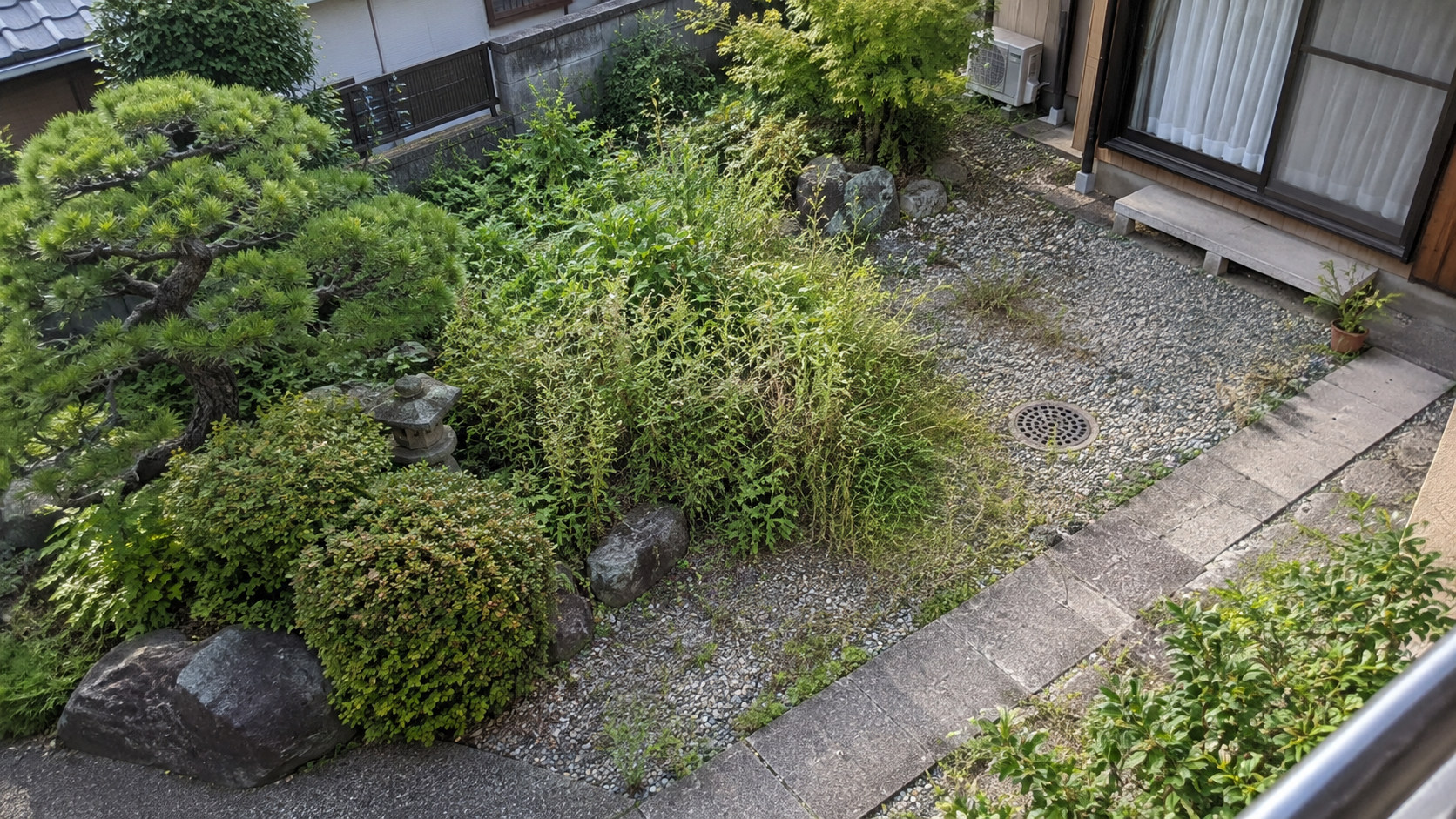 植栽・砂利・通路・排水ますがある改修前の庭